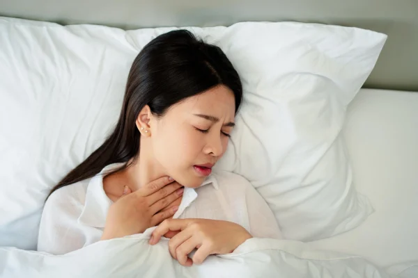 ภาพผู้หญิงเป็นกรดไหลย้อน ทำให้นอน แล้วหายใจ ไม่ค่อย ออก