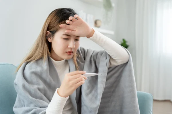 ภาพผู้หญิงใช้ปรอทวัดไข้ แต่อุณหภูมิปกติ ตัวร้อนแต่ไม่มีไข้