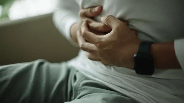 ผู้ชายที่กำลังเอามือกุมท้อง จากอาการปวดท้องที่เกิดขึ้น
